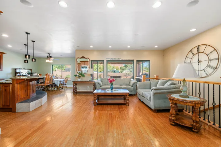 Living area with light wood-style flooring, a ceiling fan, and recessed lighting