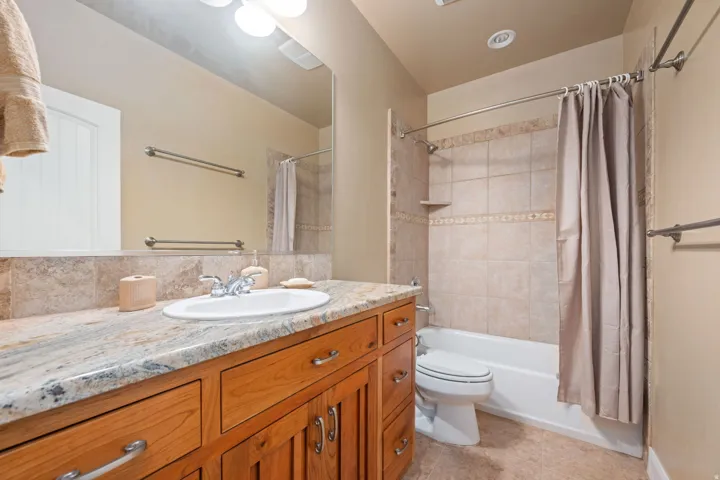 Bathroom with vanity, shower / tub combo with curtain, and light tile patterned flooring