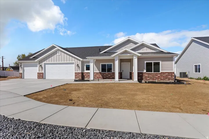 Craftsman house featuring board and batten siding, an attached garage, a porch, and concrete driveway