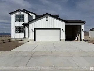Modern inspired farmhouse featuring board and batten siding, an attached garage, and driveway