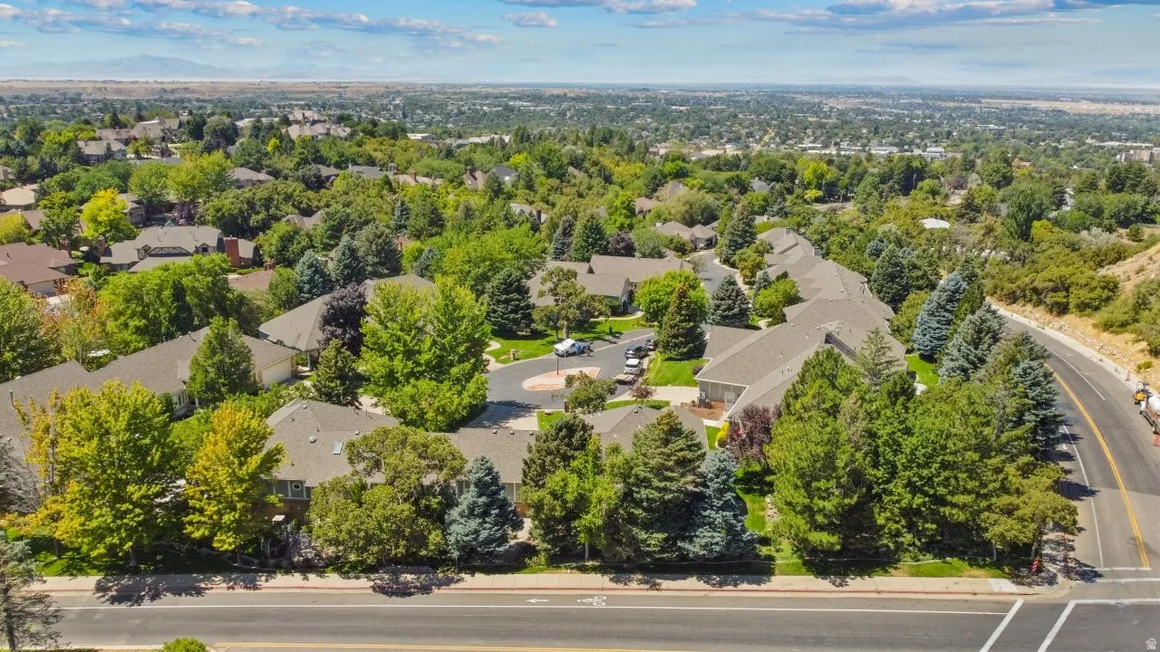 Aerial view of property's location with nearby suburban area and a tree filled landscape