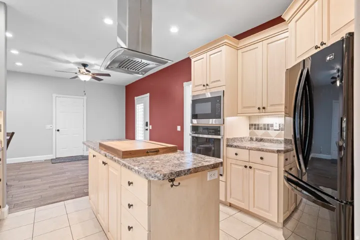 Kitchen featuring stainless steel appliances, a ceiling fan, island range hood, a center island, and recessed lighting