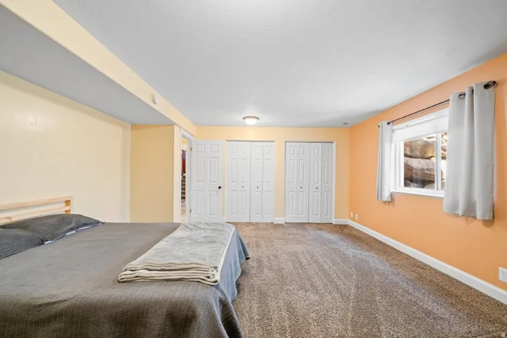 Bedroom featuring multiple closets and carpet flooring