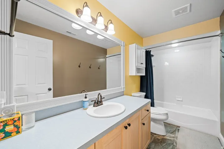 Bathroom with shower / bath combo with shower curtain and vanity
