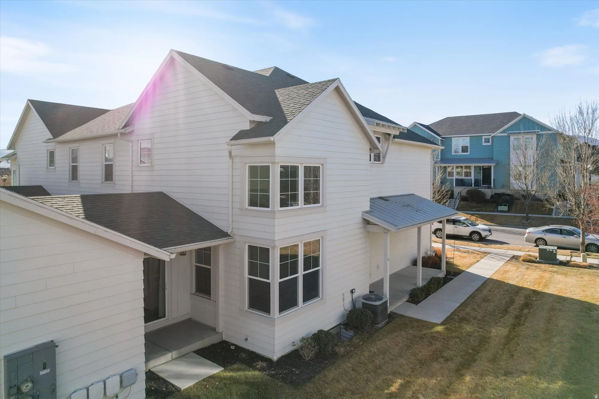 View of home's exterior with roof with shingles and a lawn
