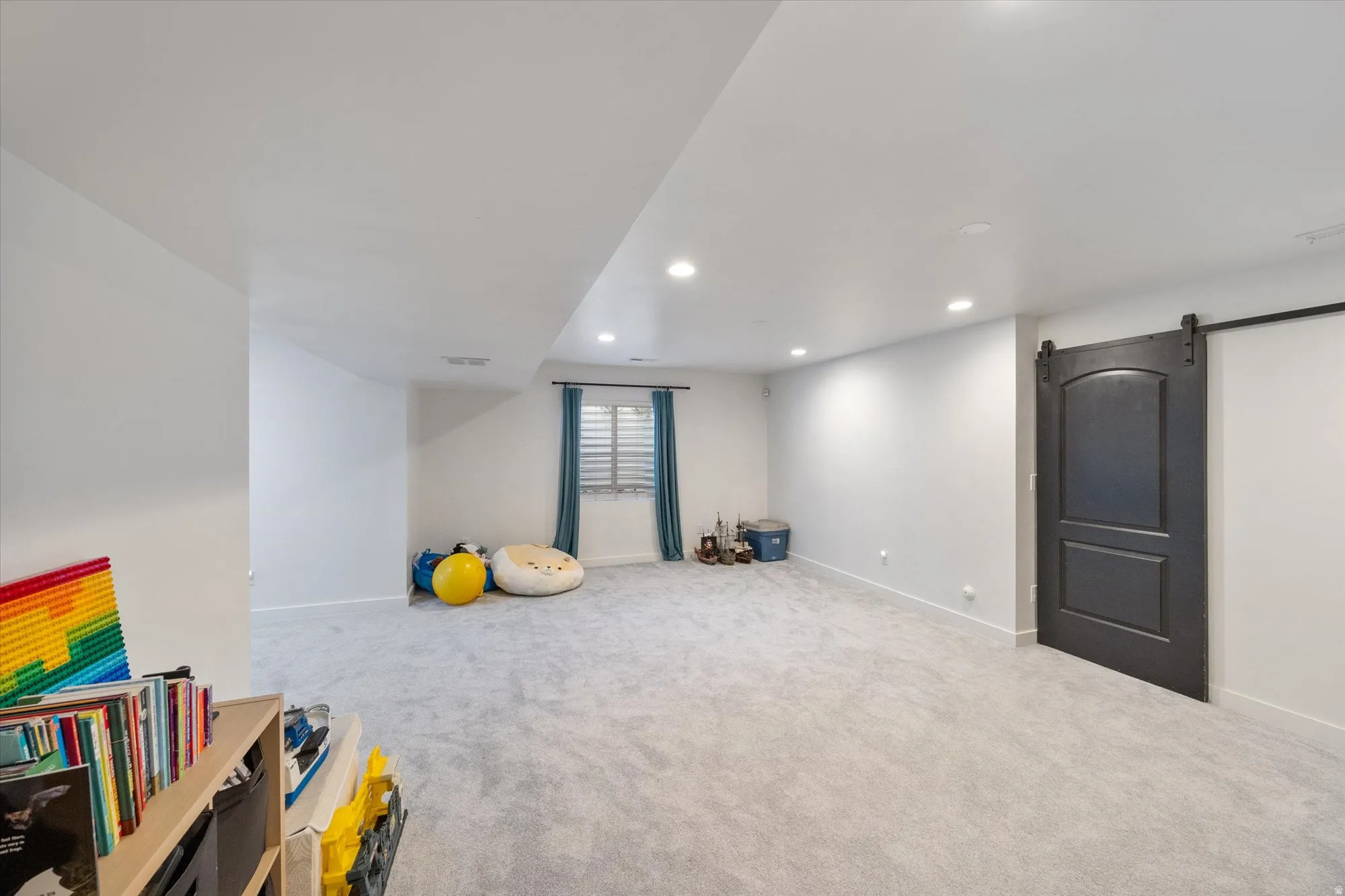 Game room with a barn door, light carpet, and recessed lighting
