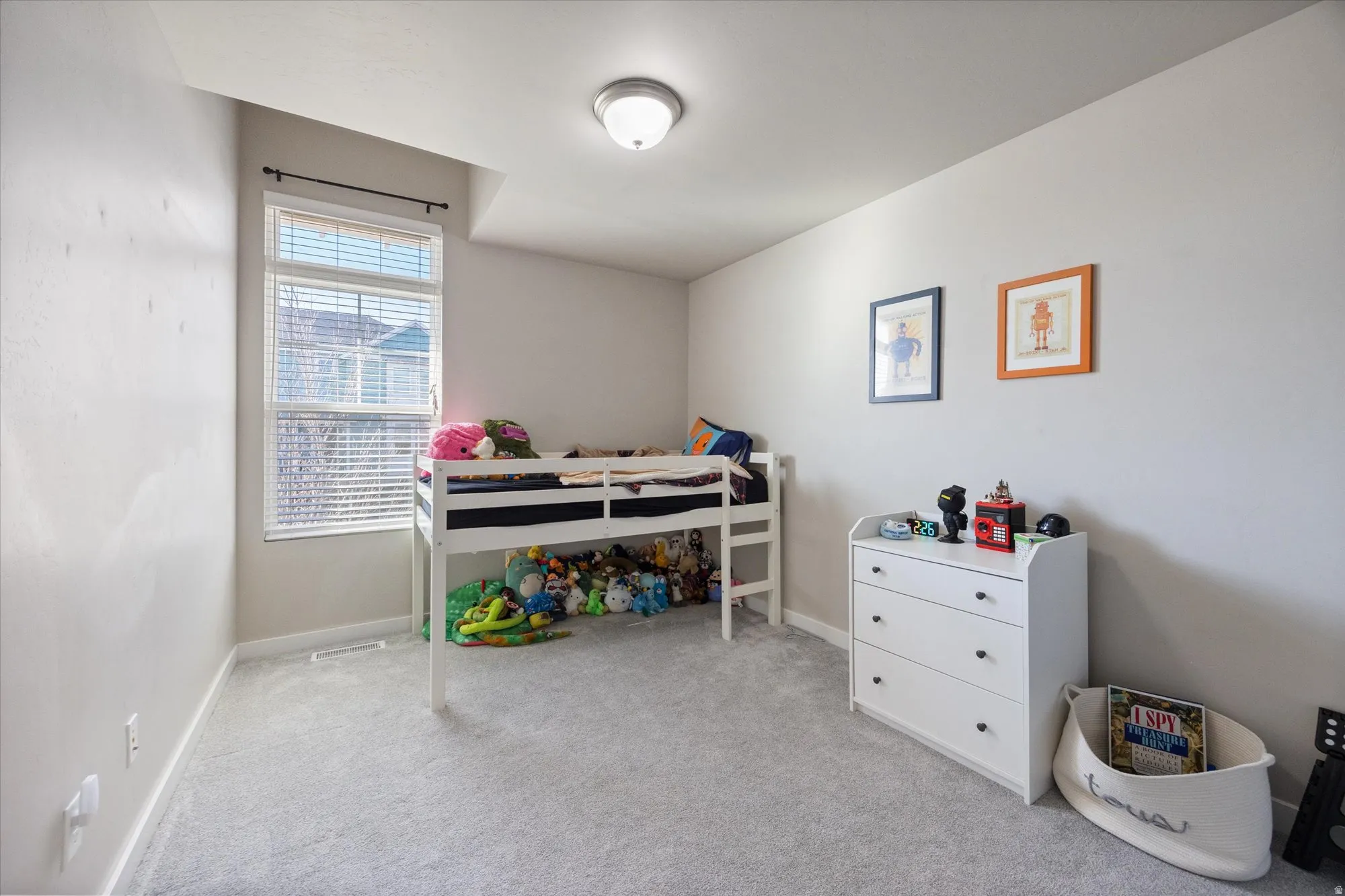 Bedroom with light colored carpet and baseboards