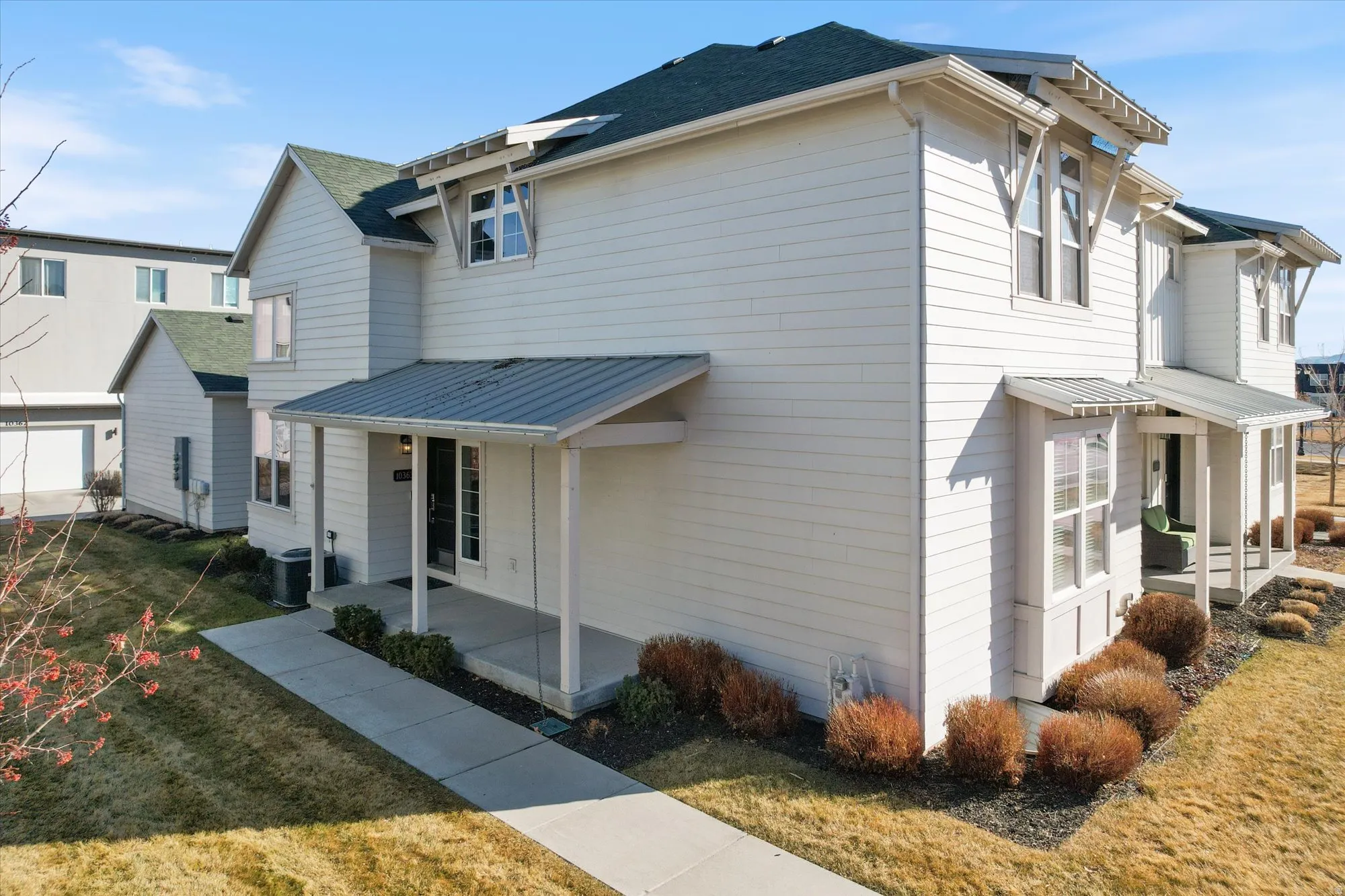 View of property exterior with a porch and a yard