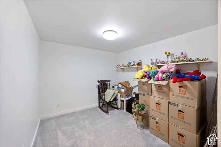 Bedroom featuring light colored carpet and baseboards