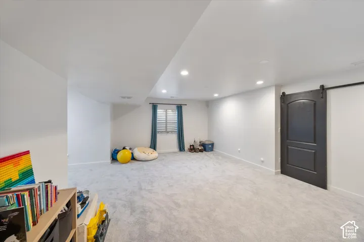 Game room with a barn door, light carpet, and recessed lighting