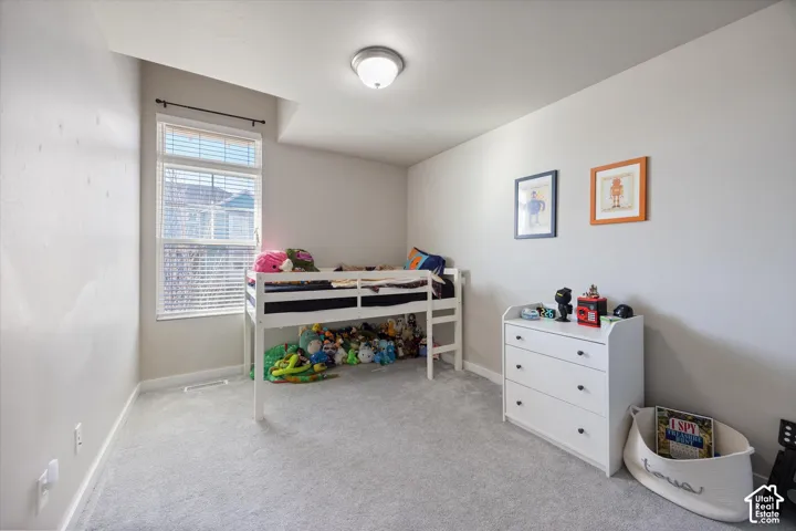 Bedroom with light colored carpet and baseboards