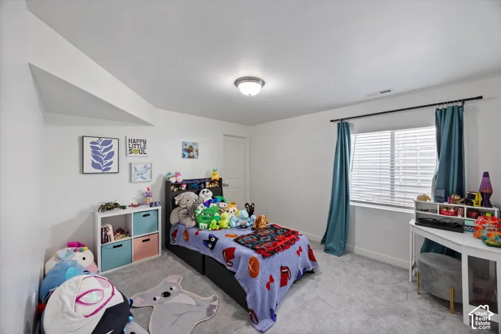 Bedroom with light colored carpet and baseboards