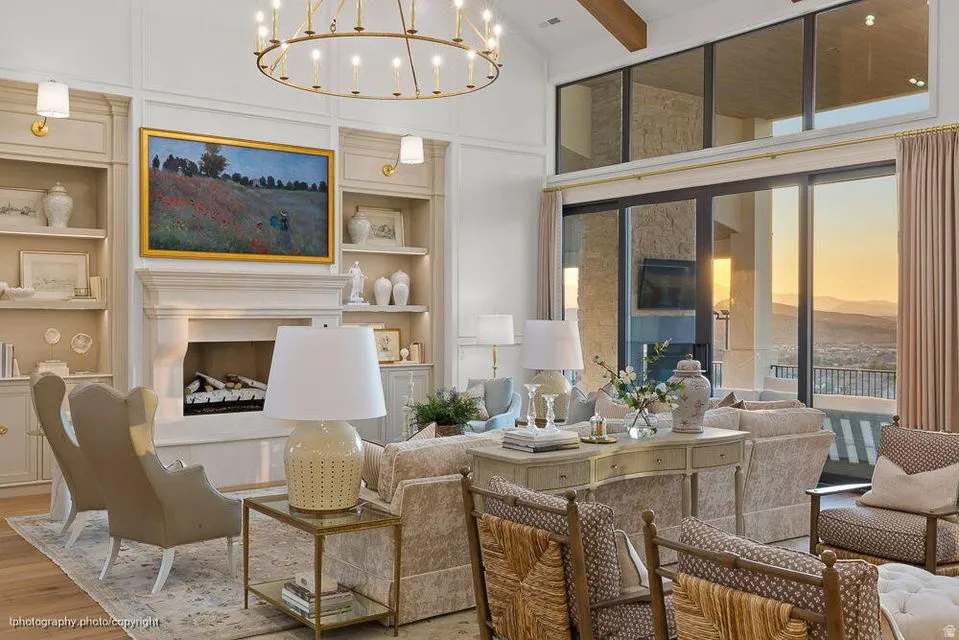 Living area featuring built in shelves, a fireplace with raised hearth, wood finished floors, and a chandelier