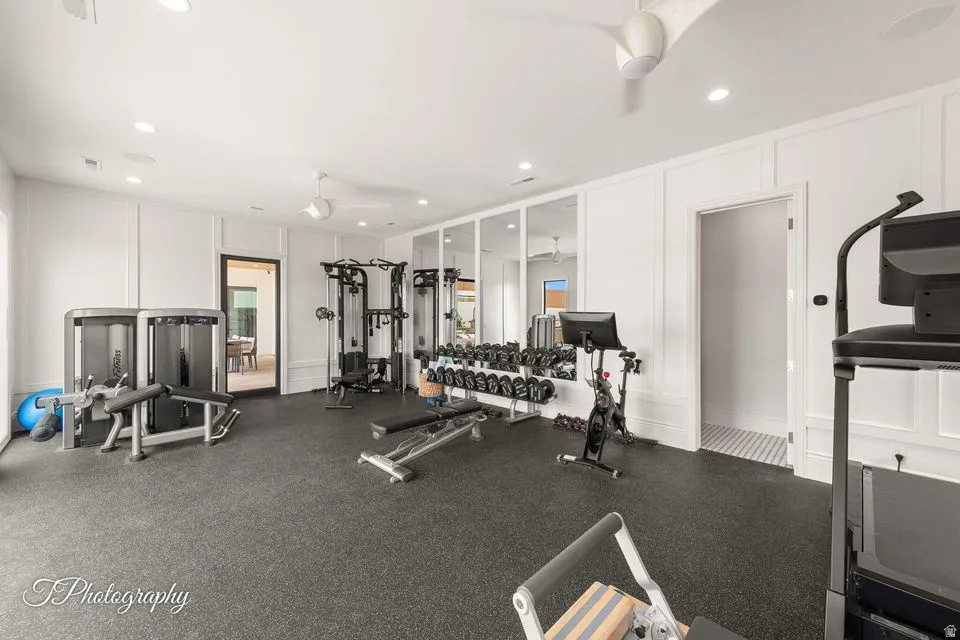 Gym with a decorative wall, ceiling fan, and recessed lighting