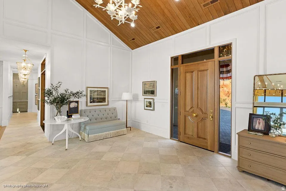 Foyer featuring a decorative wall, hanging lights, and vaulted ceiling