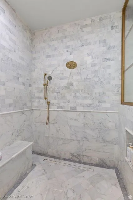 Bathroom with a tile shower and tile walls