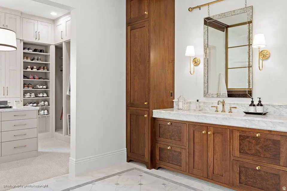 Full bath featuring vanity, inlaid floor details, and a spacious closet