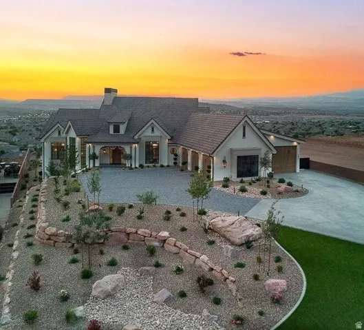 View of front facade featuring a chimney, a porch, and concrete driveway