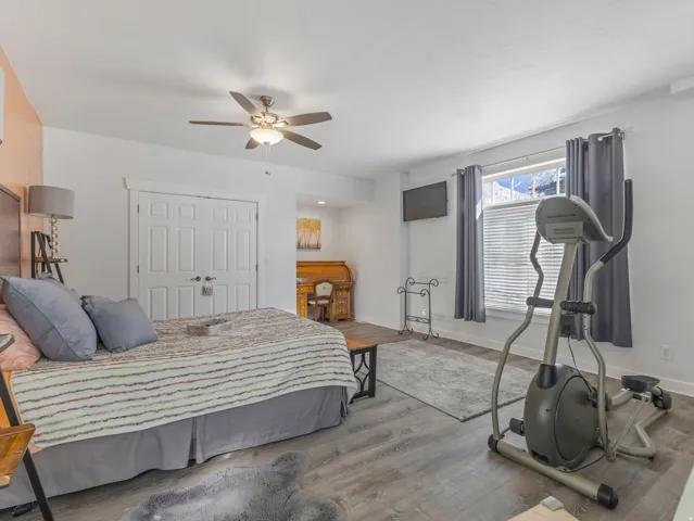 Bedroom featuring a closet, a ceiling fan, wood finished floors, and recessed lighting
