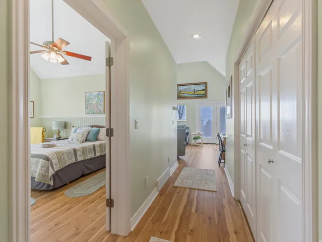Hallway featuring lofted ceiling, light wood finished floors, and recessed lighting