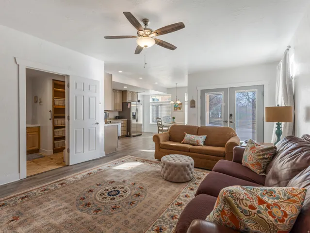 Living room featuring french doors, light wood-style flooring, and ceiling fan