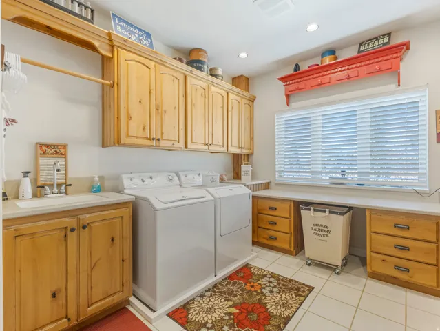 Laundry area featuring cabinet space, separate washer and dryer, light tile patterned floors, and recessed lighting