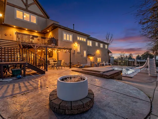 Back of property with a fire pit, outdoor dining space, a patio, and stucco siding