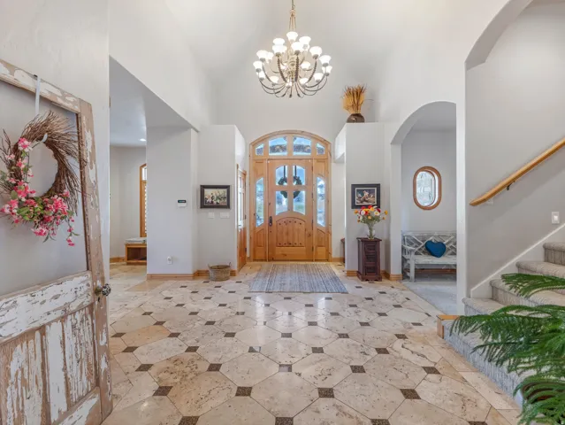 Entrance foyer with a chandelier, arched walkways, and vaulted ceiling