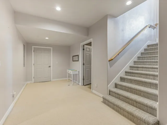 Stairway with recessed lighting and carpet floors