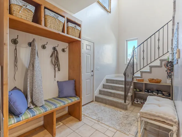 Mudroom with tile patterned floors and a high ceiling