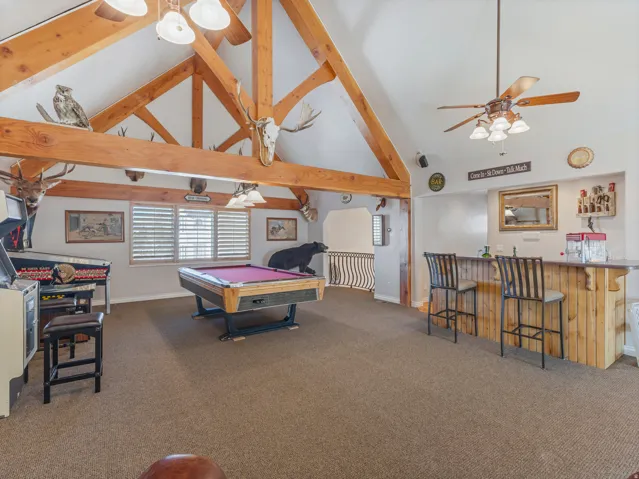 Recreation room featuring vaulted ceiling, billiards, a ceiling fan, and a community bar