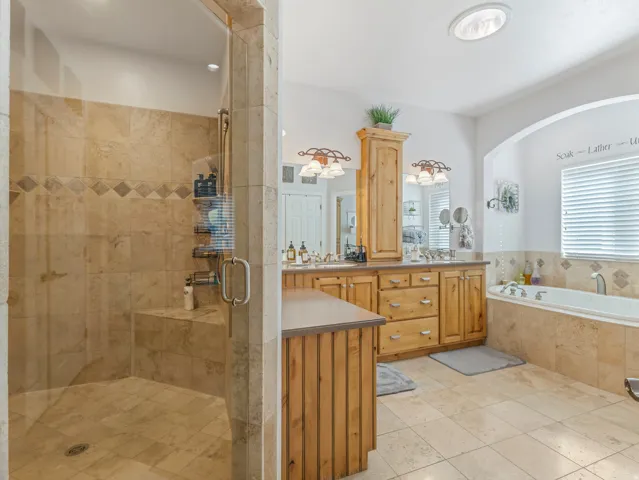 Full bathroom featuring vanity, a shower stall, a bath, and light tile patterned floors
