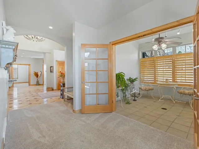 Foyer entrance with light carpet, light tile patterned floors, healthy amount of natural light, ceiling fan, and recessed lighting