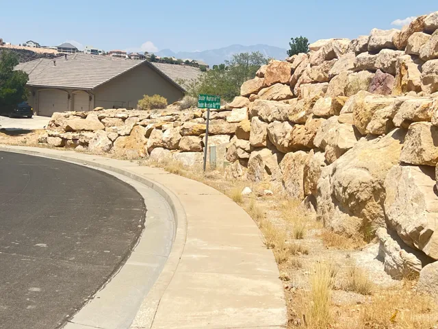 View of asphalt street featuring sidewalks, curbs, and a mountain view
