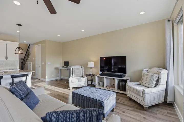 Living area with light wood-type flooring, ceiling fan, and recessed lighting