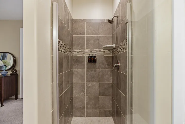 Full bath with a stall shower and carpet flooring
