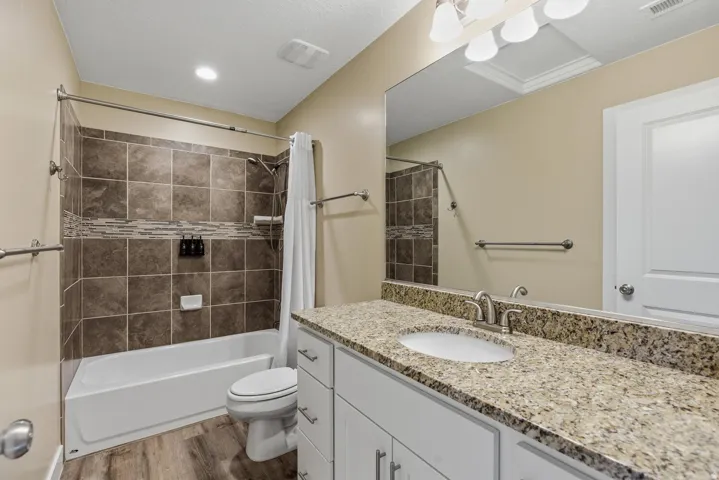 Bathroom with shower / tub combo, vanity, and light wood-style floors