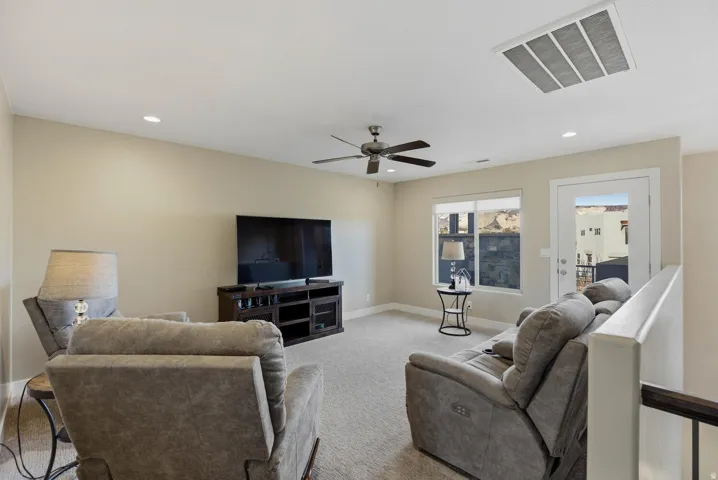 Living room with carpet floors, recessed lighting, and a ceiling fan