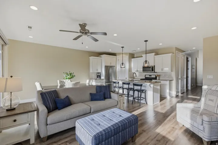 Living area featuring light wood-type flooring, ceiling fan, and recessed lighting