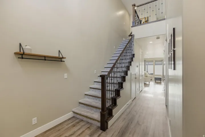 Stairway featuring wood finished floors and a high ceiling