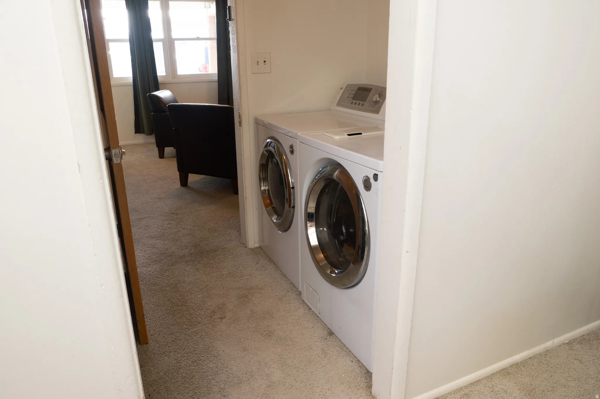 Laundry area with light carpet and independent washer and dryer