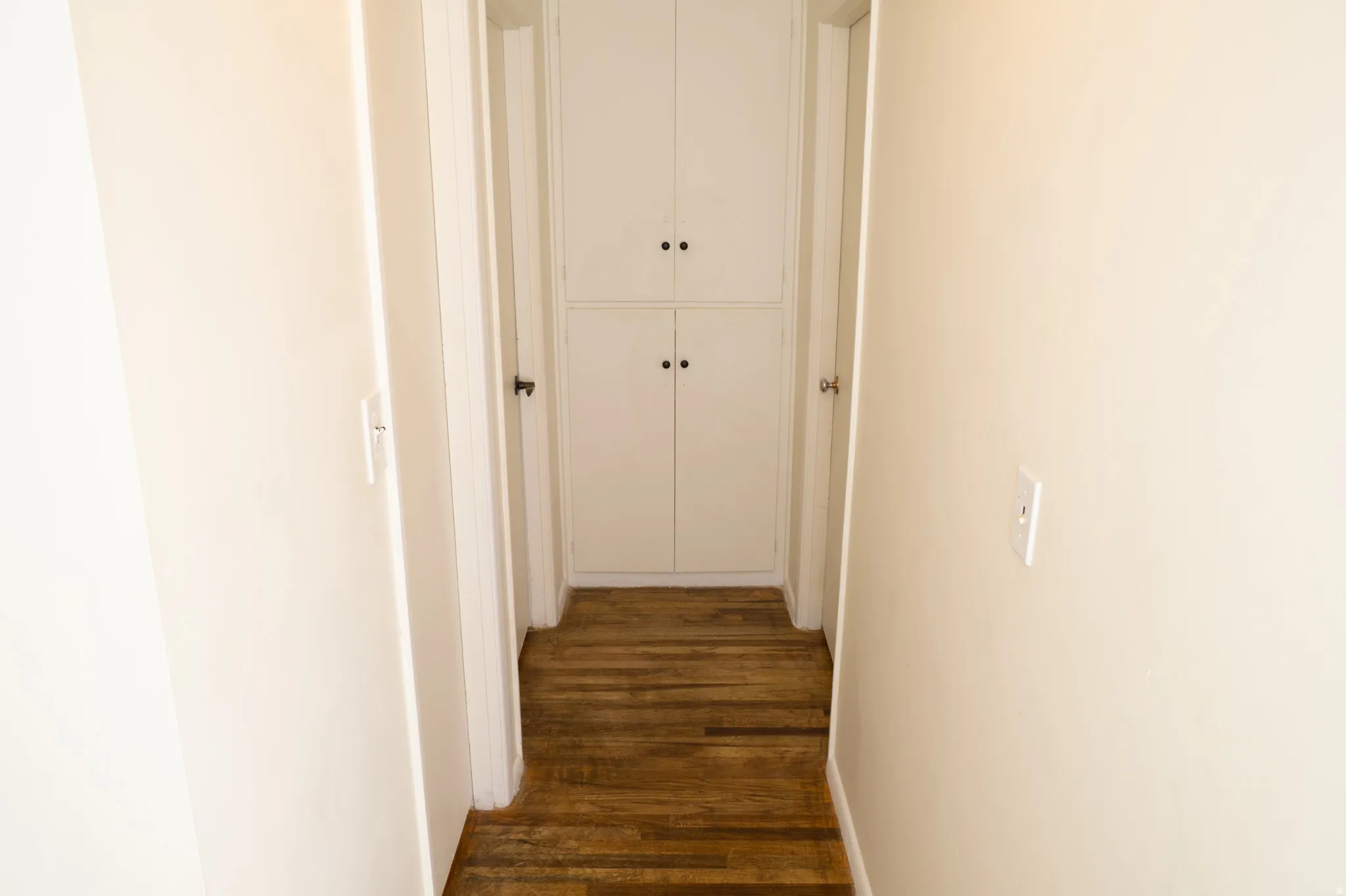 Hall featuring dark wood-type flooring