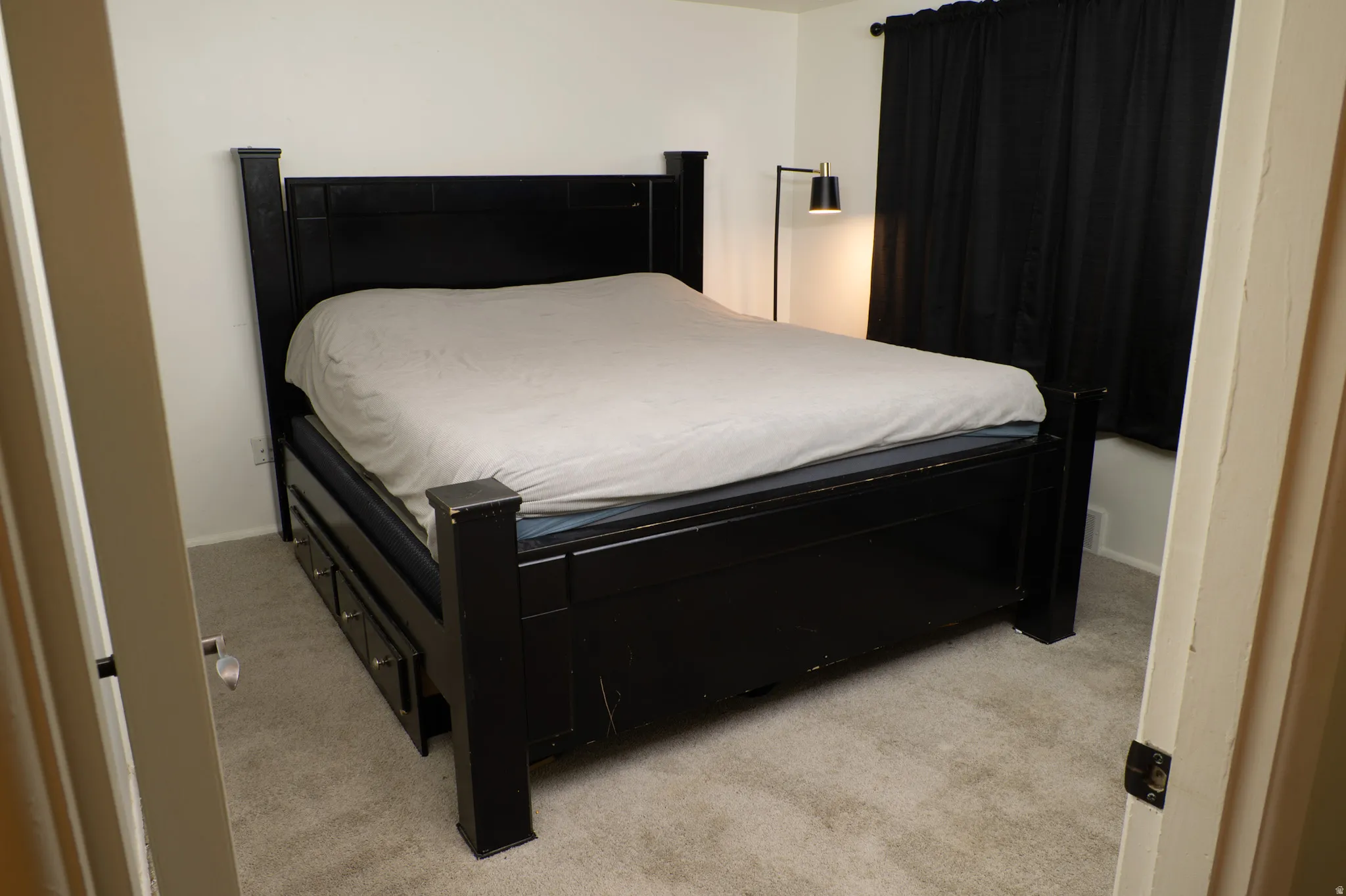Bedroom featuring light carpet and baseboards