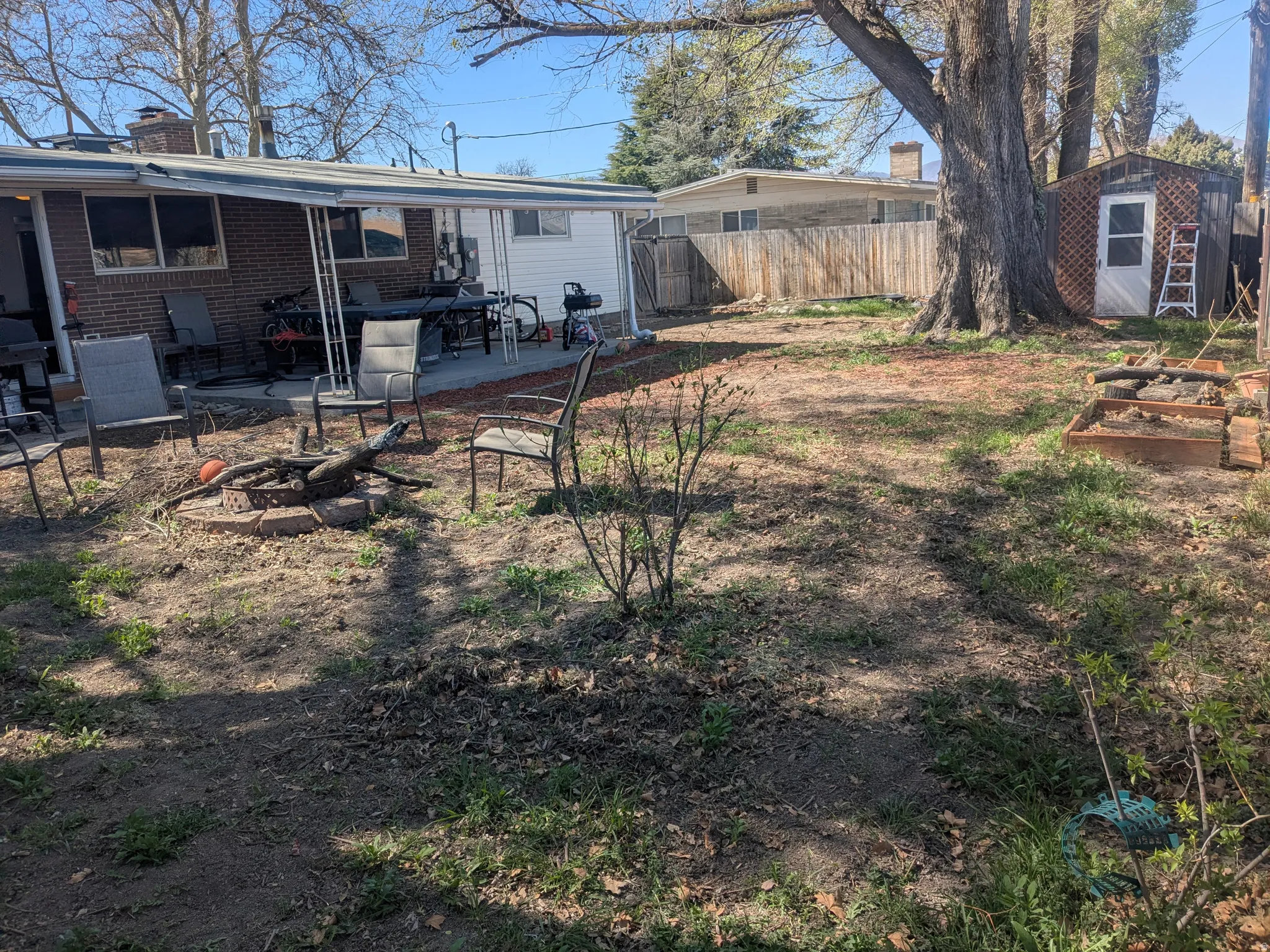 Fenced backyard featuring a shed, an outdoor fire pit, and a patio