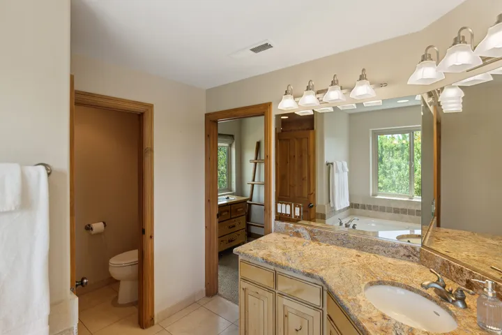 Full bathroom featuring vanity, light tile patterned floors, and a bath