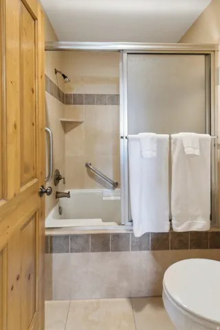 Bathroom with tiled shower / bath combo and light tile patterned floors