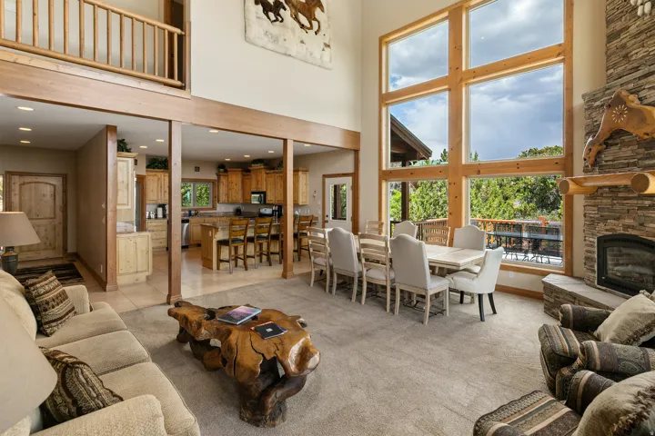 Living room featuring light colored carpet, recessed lighting, a fireplace, a high ceiling, and light tile patterned flooring
