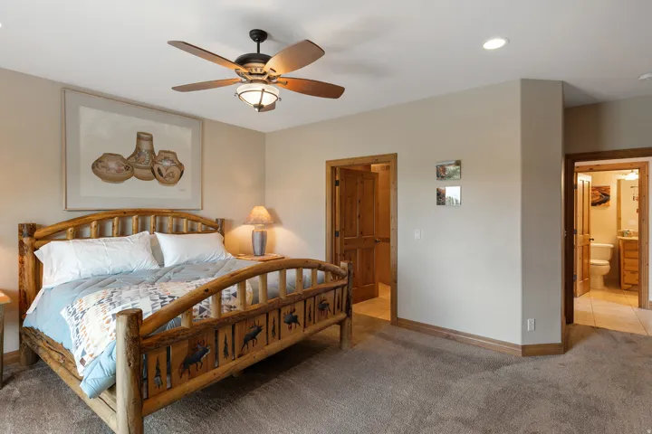Carpeted bedroom with a ceiling fan, recessed lighting, and ensuite bathroom