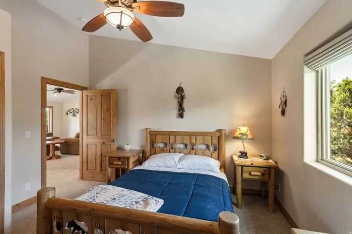 Bedroom with carpet floors, ceiling fan, and lofted ceiling