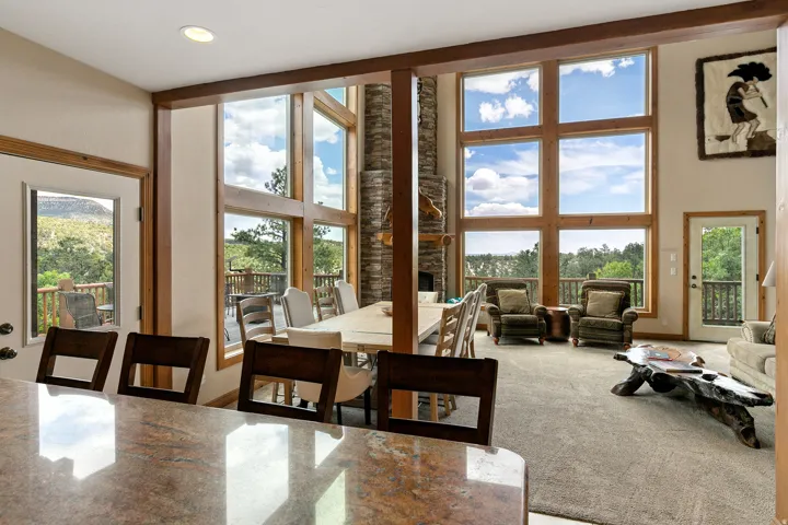 Carpeted dining area featuring a high ceiling, a fireplace, and recessed lighting
